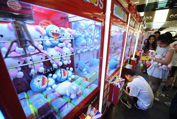 People play on a toy claw machine in Taiyuan, Shanxi province. (Photo by Deng Yinming/For China Daily)