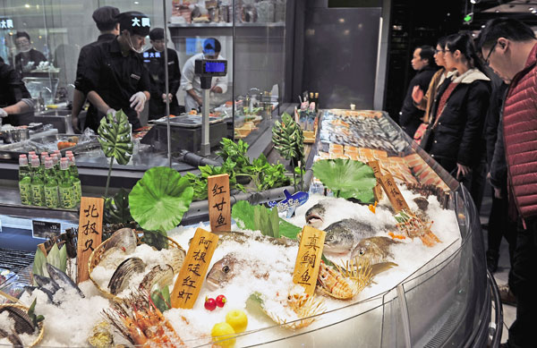 Consumers are attracted by the fresh seafood and cooking service at BravoYH in Fuzhou, Fujian province. (Photo by Zheng Shuai/For China Daily)
