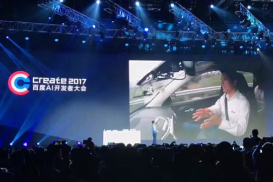 Robin Li interacts with crowd at Baidu Create 2017 AI developer conference at National Convention Center from the self-driving car on Wednesday. (Photo/Beijing Youth Daily)