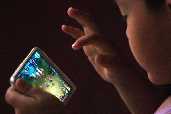 A child plays a mobile game in Dezhou, Shandong province. (Photo provided to China Daily)