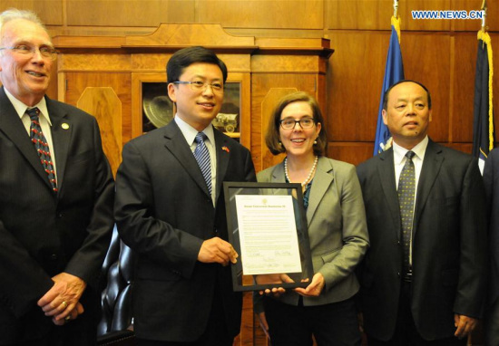 U.S. Oregon State Governor Kate Brown (2nd R) presents the document to Ren Faqiang (2nd L), Chinese deputy Consul General to San Francisco in Salem, the United States, on July 5, 2017. (Xinhua/Ma Dan)