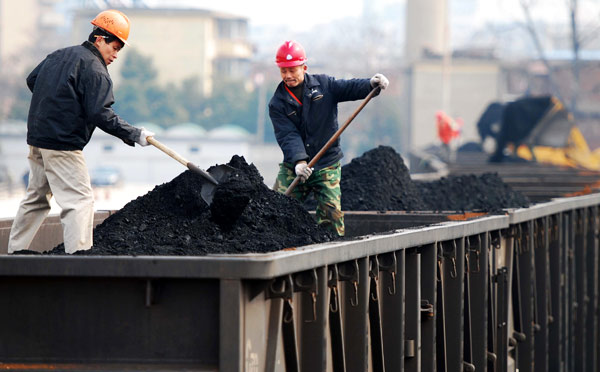 Workers load thermal coal at a storage base in Jiujiang, Jiangxi province. (Photo/Xinhua)