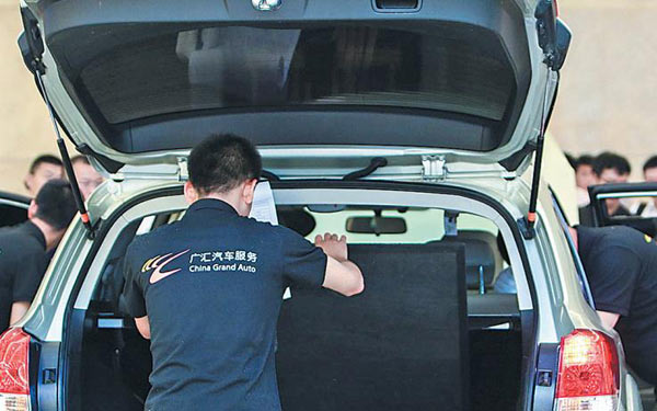 Technicians examine a used car in a contest at the 2017 China Used Car Assembly held in Wuhan, Hubei province. (Photo provided to China Daily)
