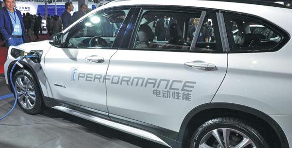 Visitors are attracted by a new energy car at the China International Industry Fair in Shanghai last year. (Photo provided to China Daily)