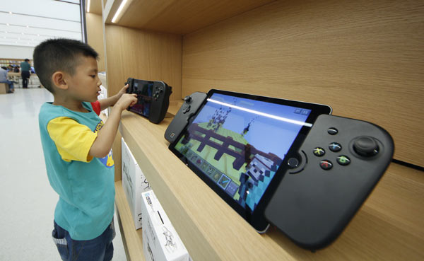 A boy plays with an Apple device at an outlet of Apple Inc in Tianjin. (Photo provided to China Daily)