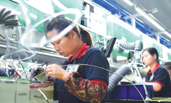 Workers operate on the lithium battery production line in Changxing county, Zhejiang province. (Photo by Liang Zhen/For China Daily)