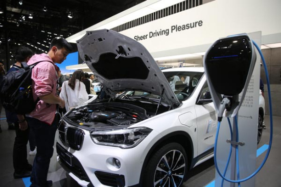 A visitor looks at a new energy car at the 2017 Shanghai auto show. (Photo by Zhang Jingang/For China Daily)