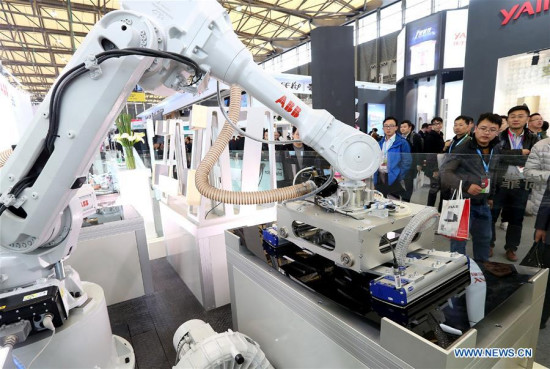 Visitors watch a robot during the Appliance & Electronics World Expo 2017 in east China's Shanghai, March 9, 2017. (Xinhua/Chen Fei)