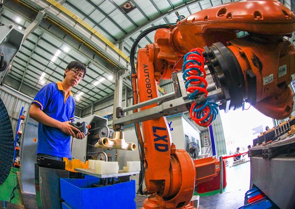 A worker assembles a robotic arm at a factory in Foshan, Guangdong province. (Photo provided to China Daily)