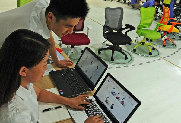 Employees of a chair-making company in Huzhou, Zhejiang province, check orders online. (Photo/Xinhua)
