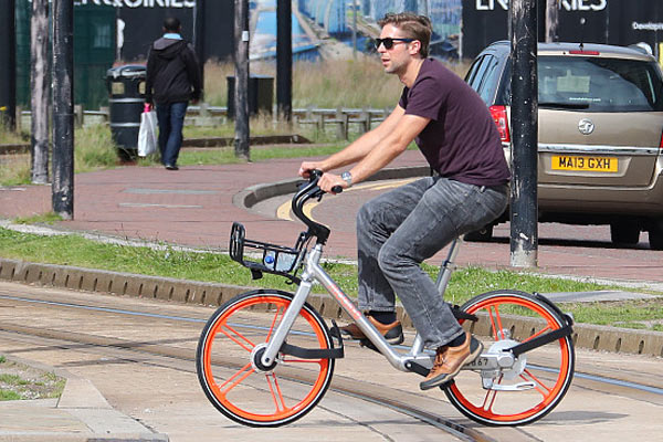 A man rides a Mobike earlier this month in Manchester, UK. The company placed 1,000 bikes in the city in June. Rival Chinese company Ofo is making a similar effort in Cambridge. (Photo provided to China Daily)
