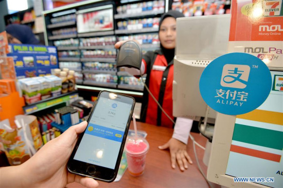 A customers uses Alipay to pay for his pill at a shop in Kuala Lumpur, Malaysia, July 24, 2017. Malaysia's second largest bank CIMB joined hands with Ant Financial, an affiliate company of Chinese e-commerce giant Alibaba, on Monday to cater to local mobile payment demands. (Xinhua/Chong Voon Chung)