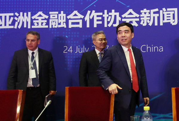 Tian Guoli (right), chairman of the new Asian Financial Cooperation Association, Hungarian banker Levente Kovacs (left) and South Korean banker Ha Yung-ku attend a news conference in Beijing on Monday. (WANG ZHUANGFEI / CHINA DAILY)