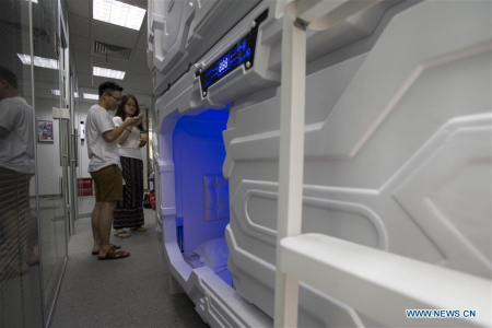 People learn how to use the shared compartment in Shanghai, east China, July 14, 2017. The shared compartment service appeared in some office buildings in Shanghai recently. People can enjoy a rest in the compartment by scanning the QR codes for payment. Disposable bedding is provided and the compartment will be disinfected automatically by ultraviolet light after use. (Xinhua/Du Xiaoyi)