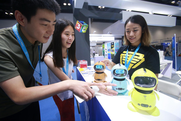 Robots attract visitors at an industry expo in Beijing. (Photo by Chen Xiaogen/For China Daily)