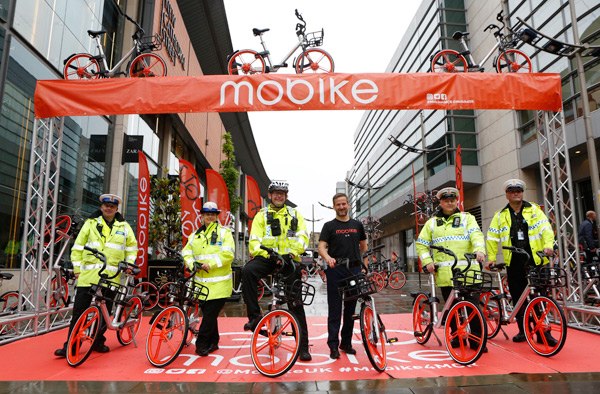 Manchester traffic police pose with Mobike bicycles at the launch of the bike-sharing services on June 29. Manchester marks the beginning of the Chinese company's global expansion, which popularizes the concept of sharing economy. XINHUA