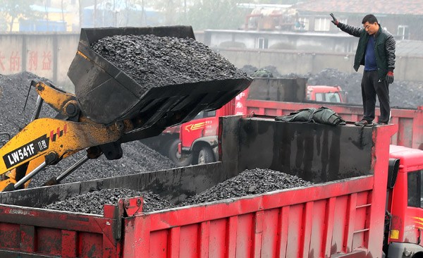 A heavy-duty lorry receives coal load at a yard in Huaibei, Anhui province. Prices of coal and metals have risen this year, boosting profits and shares of listed companies in the sectors concerned. TIAN SHENG / FOR CHINA DAILY