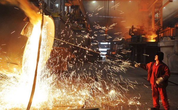 A worker cleans a steel lendle at the Dongbei Special Steel Group in Dalian, Liaoning province. (LIU DEBIN / FOR CHINA DAILY)