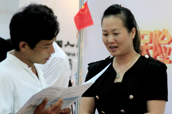 A man examines an insurance policy brochure at an industry expo in Haikou, Hainan province. (Photo by Shi Yan/For China Daily)