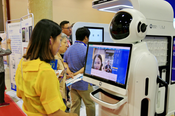 A visitor tries out a machine for fitting glasses at the 2017 China International Internet of Things Technology Expo in Beijing. (Photo: Liu Xianguo/For China Daily)