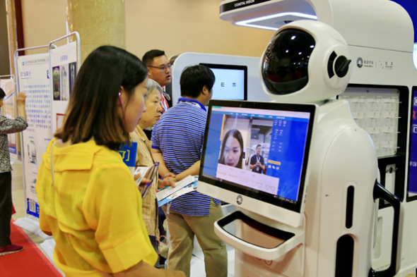 A visitor tries out a machine for fitting glasses at the 2017 China International Internet of Things Technology Expo in Beijing. (Photo: Liu Xianguo/For China Daily)