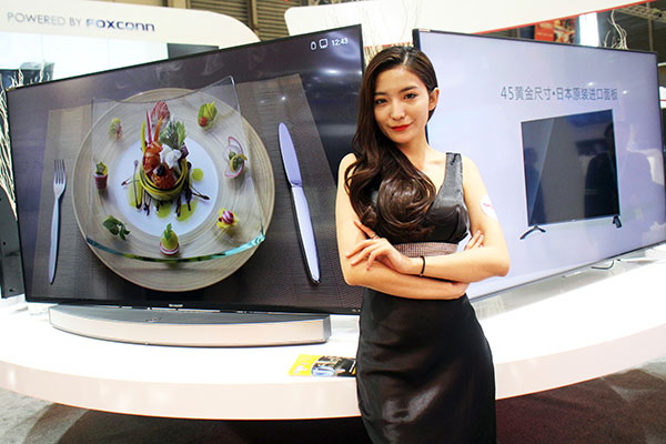 A model poses in front of two internet televisions at the Appliance& Electronics World Expo in Shanghai. XING YUN / FOR CHINA DAILY