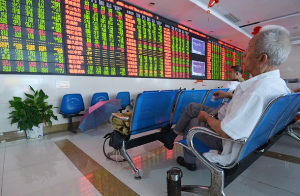 Investors check stock prices at a brokerage in Fuyang, Anhui province. On Aug 5, more than 30 stocks of defense-related, high-growth Chinese companies rose 5 percent, with nine of them hitting the daily upper limit. AN XIN / FOR CHINA DAILY