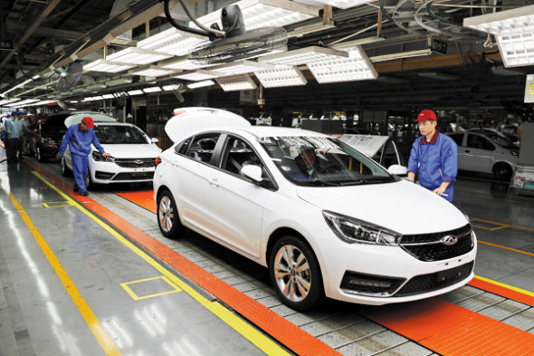 Workers check cars at Chinese automaker Chery's production line in Wuhu, Anhui province. 