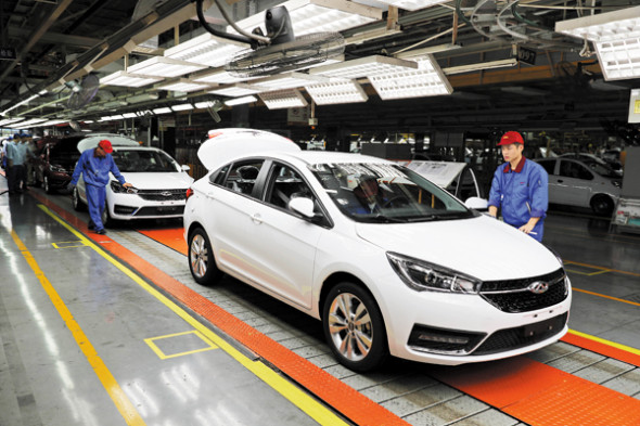 Workers check cars at Chinese automaker Chery's production line in Wuhu, Anhui province. 