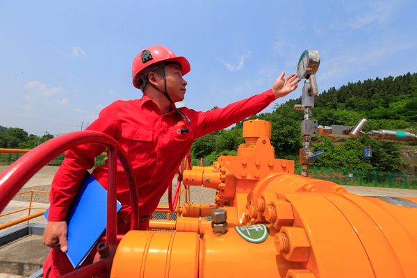 A worker from China National Petroleum Corp checks the figures on a gauge. (ZHONG MIN / FOR CHINA DAILY)