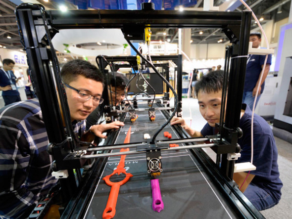 Three visitors admire a 3D printer at the Additive Manufacturing Conference of China 2017 on July 30 in Hangzhou, Zhejiang province. 