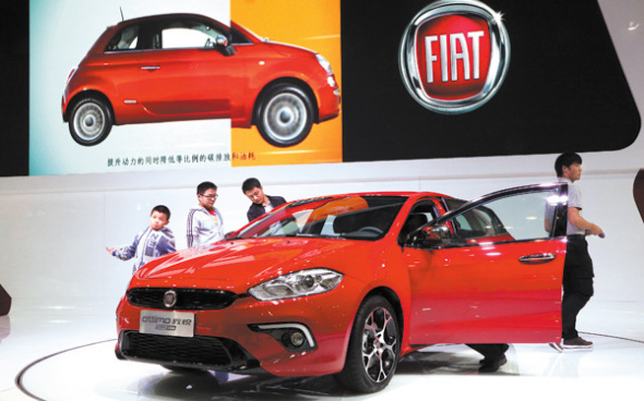 Visitors look at a Fiat model at a car expo in Zhengzhou, capital city of Henan province.