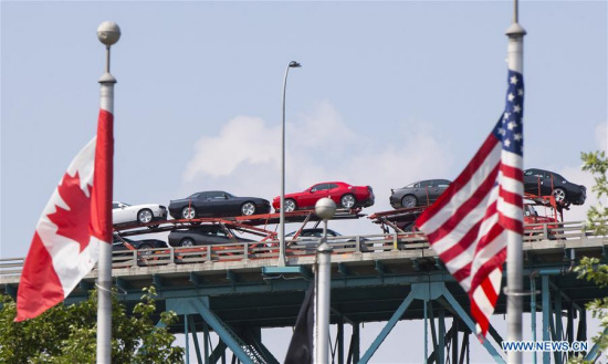 An auto transport carrier crosses the Ambassador Bridge heading to the United States in Windsor, Ontario, Canada, on Aug. 16, 2017.(Xinhua/Zou Zheng)
