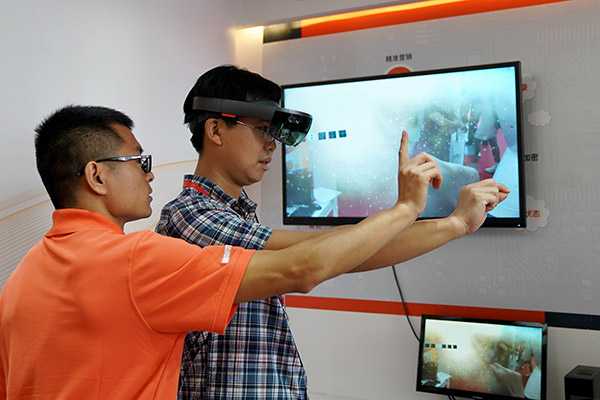 Participants try mixed reality technology applications at the 25th China International Financial Exhibition held from July 27 to 30 in Beijing. (Photo/Xinhua)