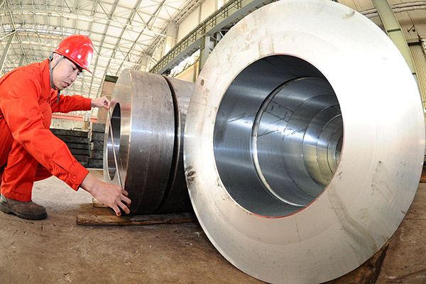 A technician at Dalian Special Steel Co Ltd, in Liaoning province, inspects the steel products at a workshop. (Liu Debin/for China Daily)