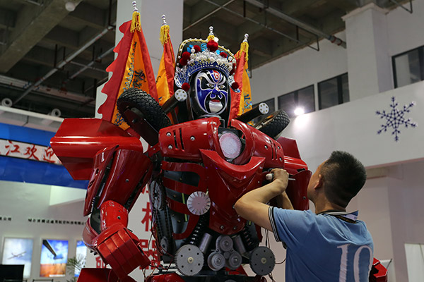 An exhibitor adjusts a robot on display at the ongoing World Robot Conference in Beijing. (Photo:China Daily/Wang Zhuangfei)