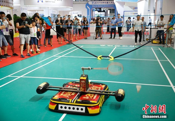 HFAI, a robot of Shanghai Hefu Holding (Group) Co Ltd, plays badminton with a human at the 2017 World Robot Conference at Beijing Etrong International Conference and Exhibition Center in Beijing, Aug 23, 2017.(Photo/Chinanews)