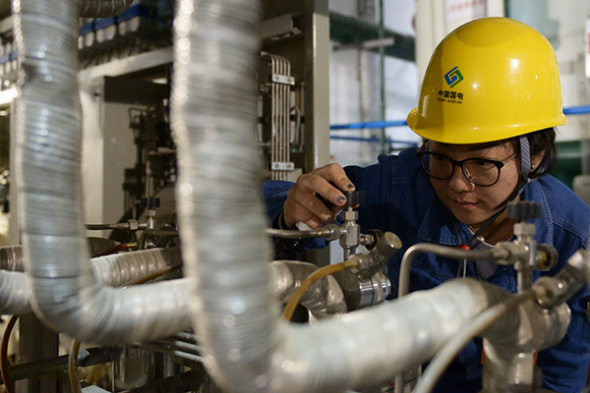 A technician of China Guodian Corp checks facilities in Lanzhou, capital of Gansu province. The merger between China Guodian Corp and Shenhua Group has been approved. (Photo/Xinhua)
