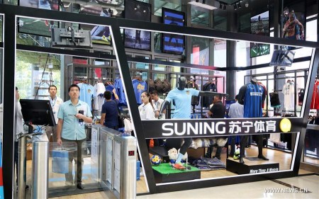 Customers purchase goods at an unmanned store of China's e-commerce platform Suning Appliance in Nanjing, capital of east China's Jiangsu Province, Aug. 28, 2017. The unmanned store, which recognizes customers' identity through face recognition system, is able to automatically collect money from customers when they take commodities to pass through a payment gateway. The money collection is realized with Suning-bolstered financial system. (Xinhua/Li Yuze)