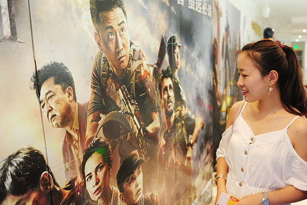 A young moviegoer looks at a poster for the Chinese film Wolf Warriors II at a cinema in Fuyang, East China's Anhui province. (Wang Biao/for China Daily)