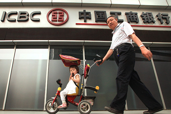 A man with a baby carriage walks past an outlet of Industrial and Commercial Bank of China in Beijing. (Photo provided to China Daily)
