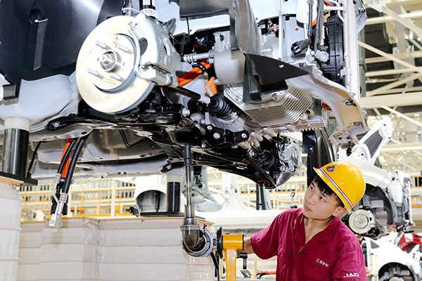 A worker fastens a screw at a production line in a JAC Motors plant in Anqing, Anhui province. (Jiang Sheng/for China Daily)