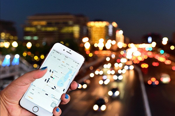 A Chinese mobile phone user uses the taxi-hailing app Didi Chuxing on her smartphone. (Photo/Xinhua)