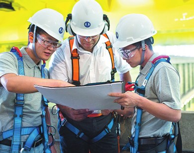 Technicians from China and Brazil discuss engineering plans for constructing a hydro plant by CTG Brasil. (Photo/China Daily)