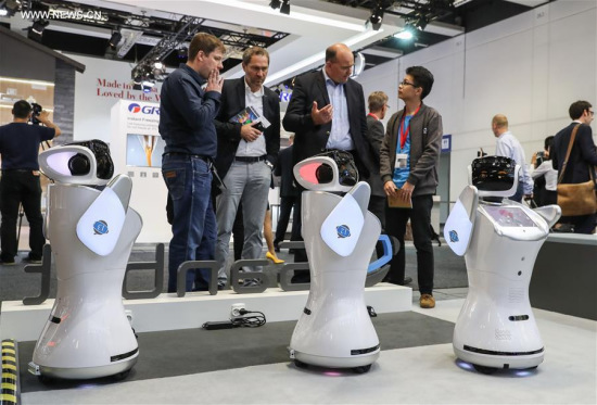 Visitors look at robots displayed at the booth of Qihan Technology from China during the 2017 IFA consumer electronics fair in Berlin, capital of Germany, on Sept. 1, 2017. The IFA 2017, which attracts about 1,800 exhibitors from all over the world, kicked off on Friday and will last until Sept. 6. (Xinhua/Shan Yuqi)