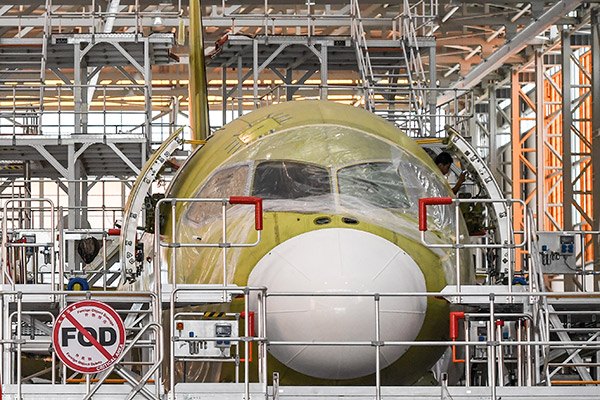 A man works on a China's home-grown C919 passenger jet at Manufacturing and Final Assembly Center of state-owned Commercial Aircraft Corporation of China, July 26, 2017. (Photo/Xinhua)