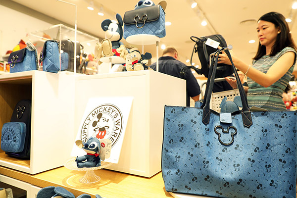 Visitors examine products at a Disney shop in Shanghai, which opened last week. (Photo/China News Service by Tang Yanjun)