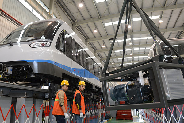 Workers at a magnetic levitation train manufacturing company in Zhuzhou, Hunan province. (Xu Xing/for China Daily)