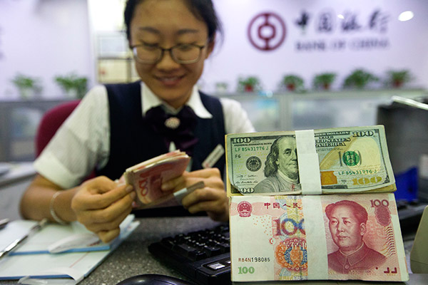 A bank clerk counts currency at a bank outlet in Taiyuan, capital of Shanxi province. (Photo/China News Service by Zhang Yun)