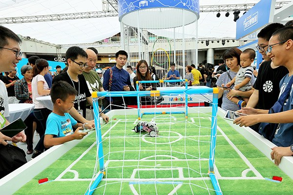 Robot lovers play with Makeblock products at a technology carnival organized by the company in Shenzhen. (Photo provided to China Daily)